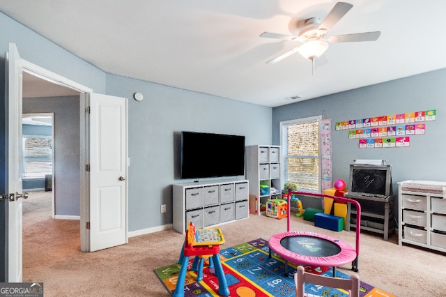 playroom featuring light carpet, ceiling fan, and baseboards