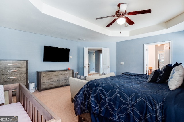 bedroom featuring a tray ceiling, ceiling fan, and carpet