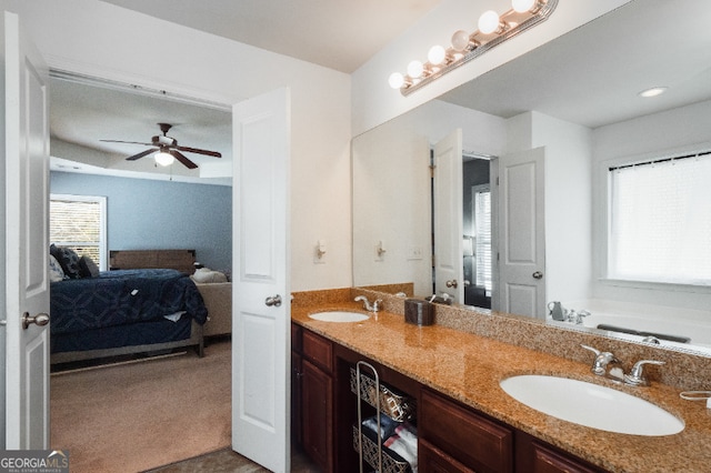 full bathroom with a sink, double vanity, ensuite bath, and a ceiling fan