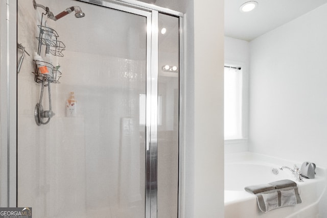 bathroom with a shower stall and a bath