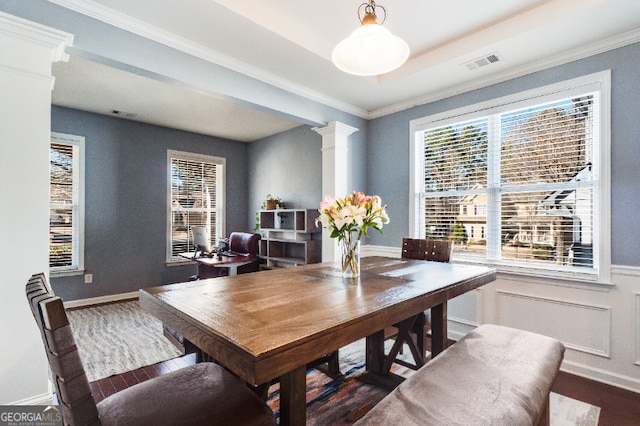 dining area featuring wainscoting, dark wood finished floors, visible vents, and ornate columns