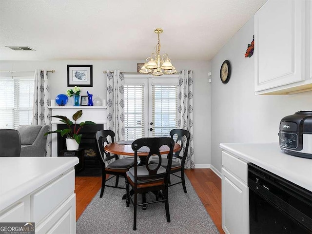 dining space with visible vents, a notable chandelier, light wood-style flooring, and baseboards