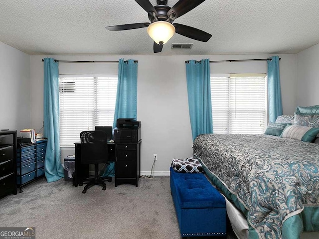 bedroom featuring visible vents, light carpet, a textured ceiling, and multiple windows