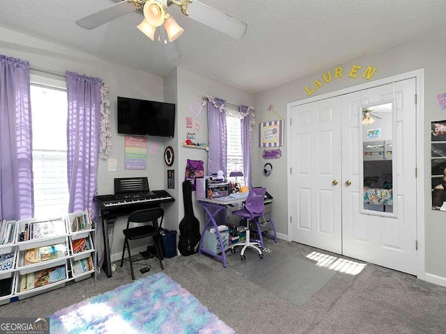 office space with a textured ceiling, carpet flooring, a ceiling fan, and baseboards