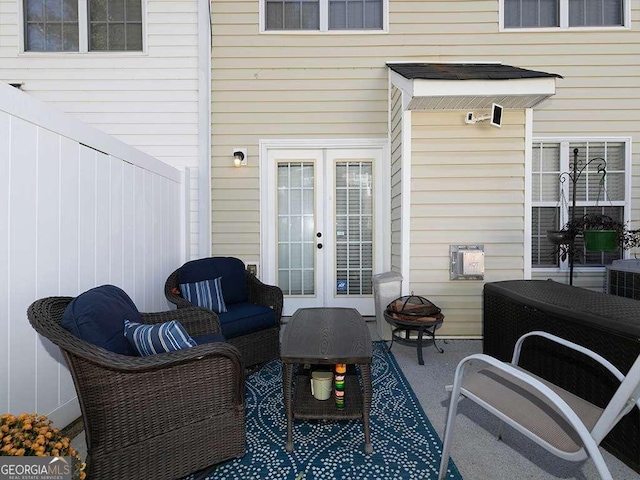view of patio / terrace featuring an outdoor living space with a fire pit, fence, and french doors