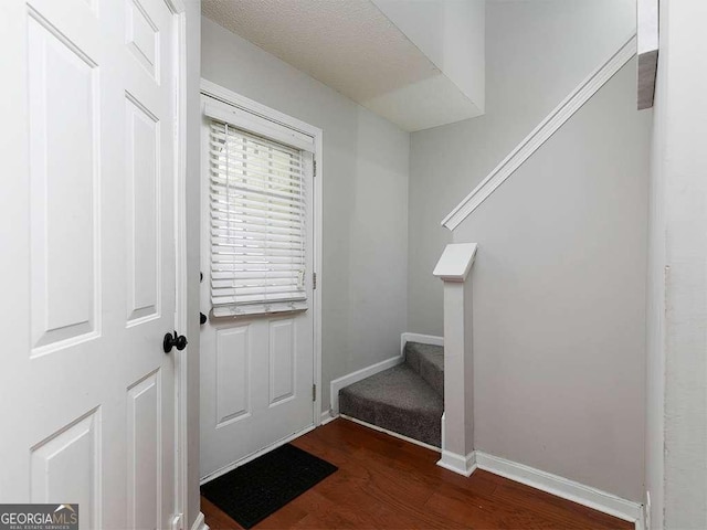 doorway to outside with baseboards, stairway, and dark wood-type flooring