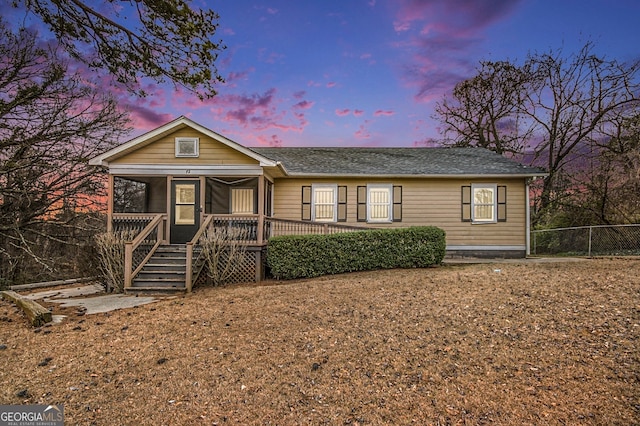 view of front facade featuring a sunroom and fence