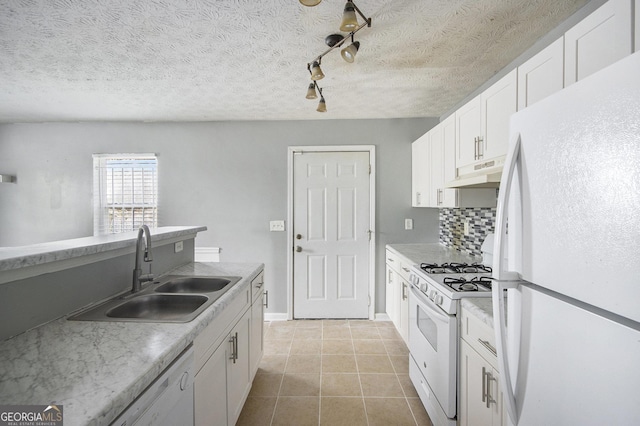 kitchen with white appliances, light countertops, a sink, and under cabinet range hood