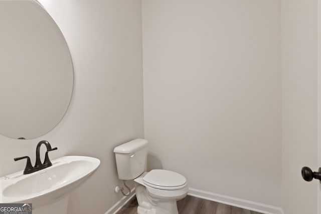 141 Roxeywood Way, Winder, GA 30680 - half bath with wood finished floors, a sink, toilet, and baseboards