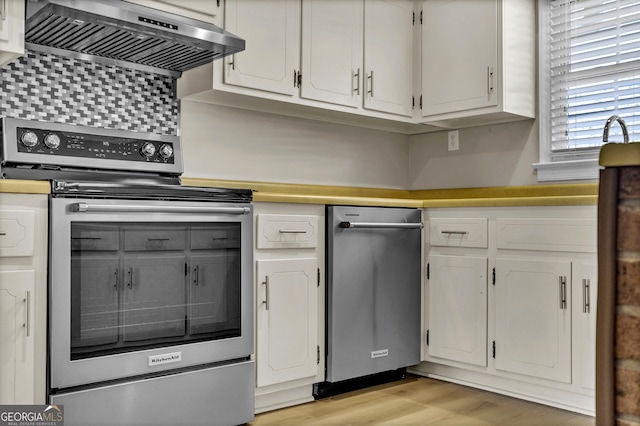 kitchen featuring range hood, light countertops, light wood-style floors, white cabinetry, and stainless steel range with electric stovetop