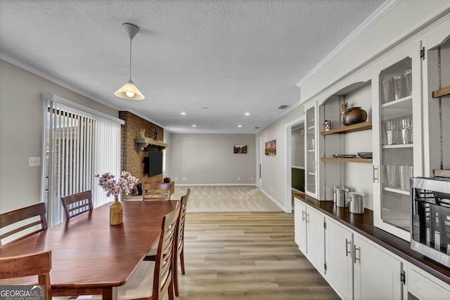 dining room with baseboards, ornamental molding, a textured ceiling, light wood-style floors, and recessed lighting