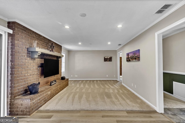 living room with baseboards, visible vents, light wood-style flooring, and crown molding