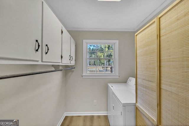 laundry area with cabinet space, baseboards, light wood-style flooring, independent washer and dryer, and crown molding