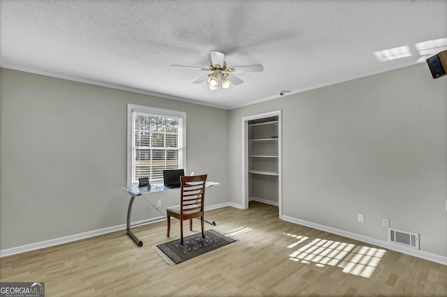 office area featuring ceiling fan, a textured ceiling, wood finished floors, and visible vents