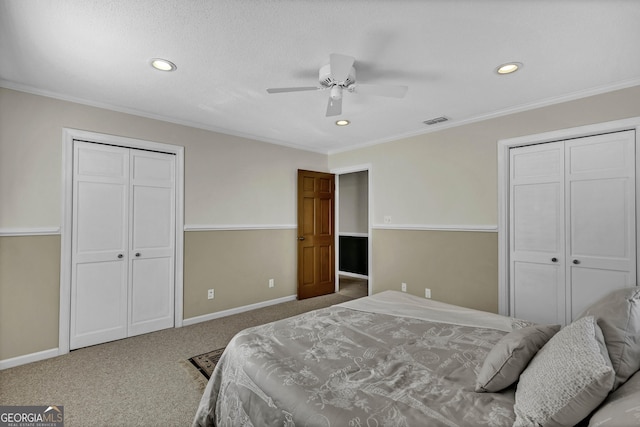 bedroom with carpet floors, baseboards, visible vents, and multiple closets