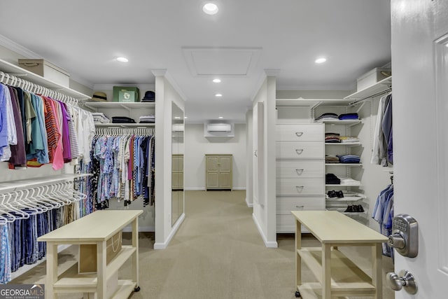 spacious closet featuring a wall mounted air conditioner, attic access, and light colored carpet