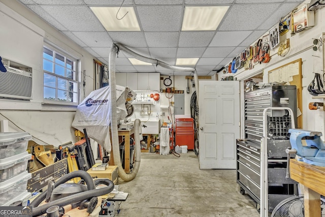 interior space with a paneled ceiling, cooling unit, and a workshop area