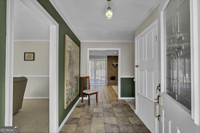 entryway featuring a textured ceiling, ornamental molding, and baseboards