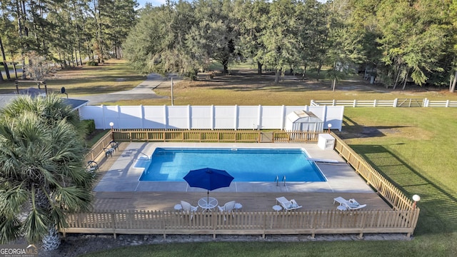 view of swimming pool with a fenced in pool, a fenced backyard, and a lawn