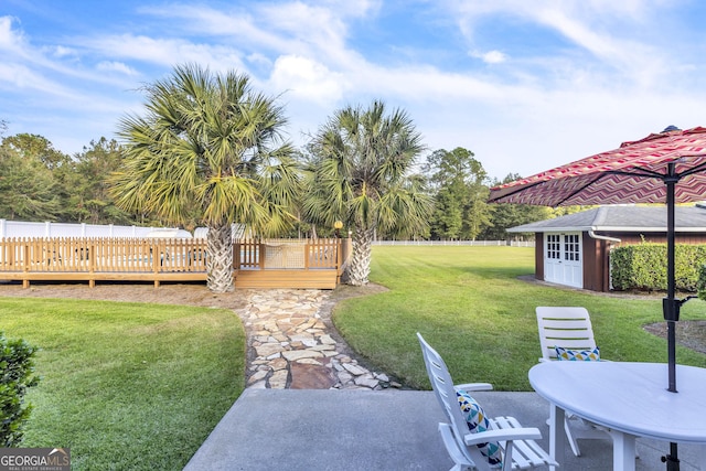 view of yard featuring an outbuilding, a fenced backyard, a deck, and a storage shed