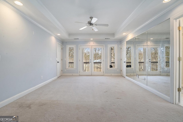 unfurnished sunroom featuring ceiling fan, french doors, and a tray ceiling