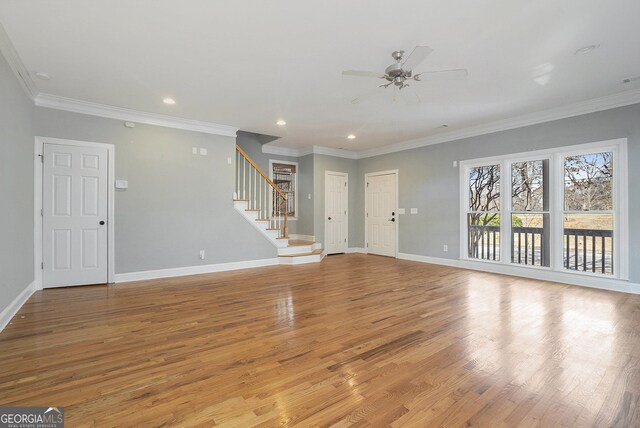 unfurnished living room with baseboards, light wood finished floors, and stairs