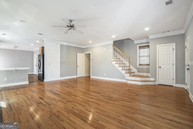 unfurnished living room featuring visible vents, stairway, baseboards, and wood finished floors