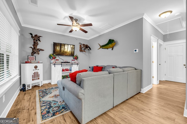 living room featuring visible vents, attic access, ornamental molding, light wood-type flooring, and baseboards