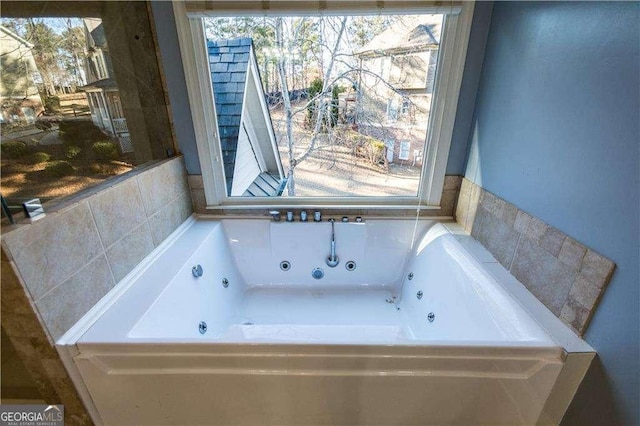 full bath featuring a healthy amount of sunlight and a jetted tub