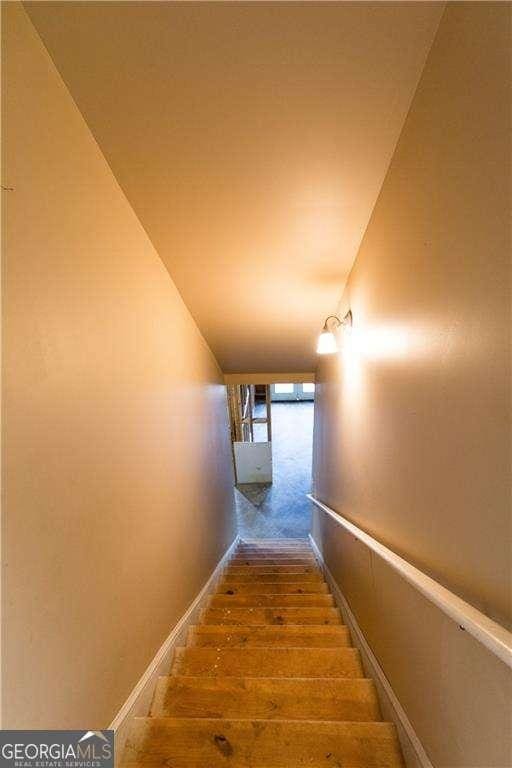 stairway with baseboards and wood finished floors