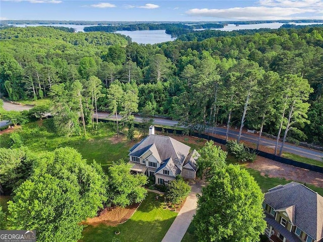 bird's eye view with a water view and a wooded view