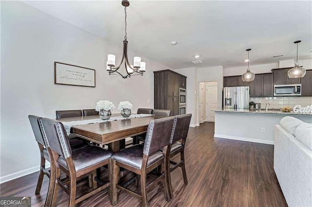 dining room with baseboards, dark wood finished floors, and a notable chandelier