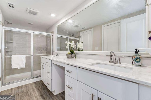 bathroom with visible vents, a sink, and wood finished floors