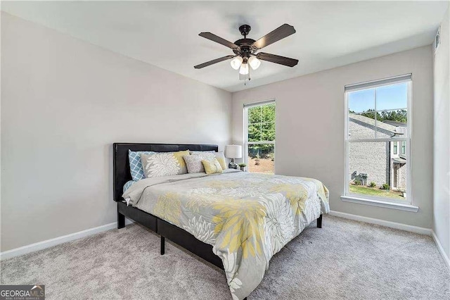 bedroom with baseboards, a ceiling fan, and light colored carpet