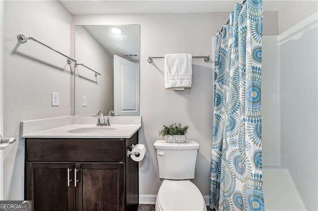 full bathroom featuring a shower with shower curtain, vanity, and toilet