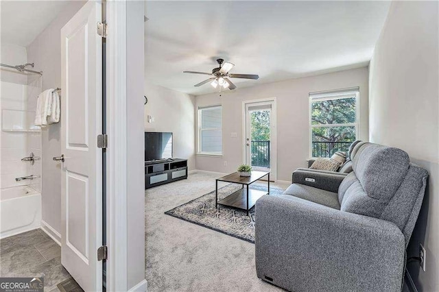 living room with ceiling fan, carpet flooring, and baseboards