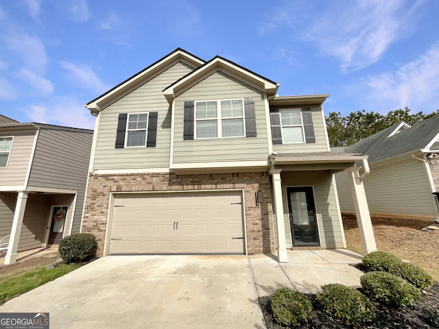 view of property with an attached garage, concrete driveway, and brick siding