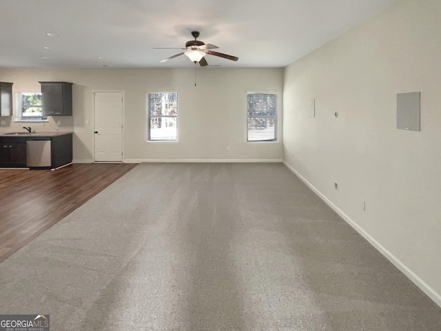 unfurnished living room with a sink, baseboards, and a ceiling fan