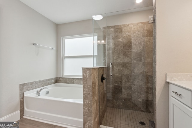 full bath featuring a garden tub, vanity, and a stall shower