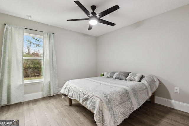 bedroom with wood finished floors, a ceiling fan, and baseboards