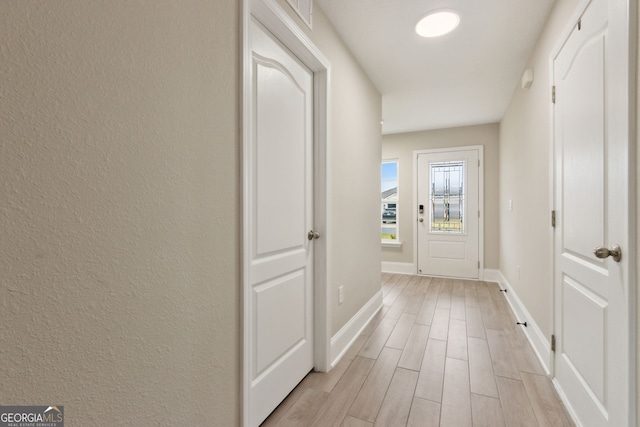 doorway featuring wood tiled floor, visible vents, and baseboards