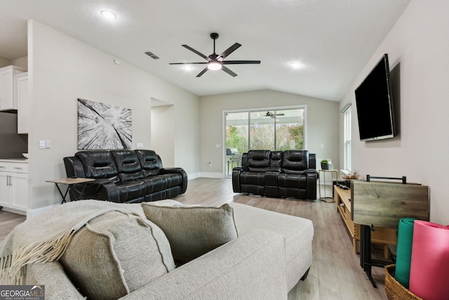 living room featuring lofted ceiling, ceiling fan, light wood finished floors, and baseboards