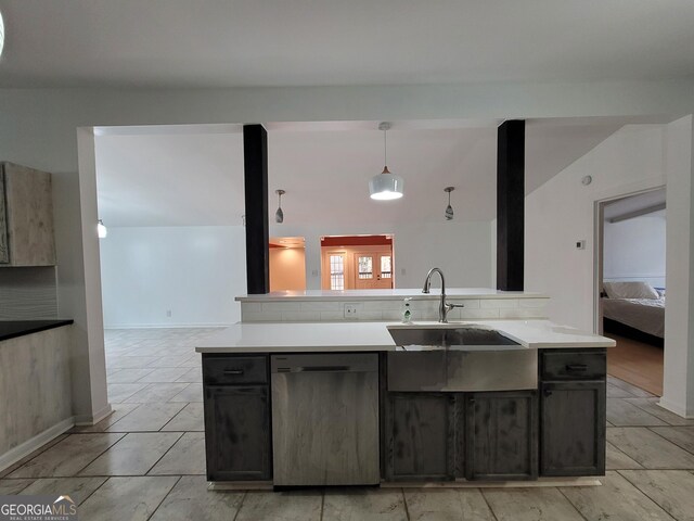 kitchen featuring decorative light fixtures, light countertops, appliances with stainless steel finishes, a sink, and dark brown cabinets