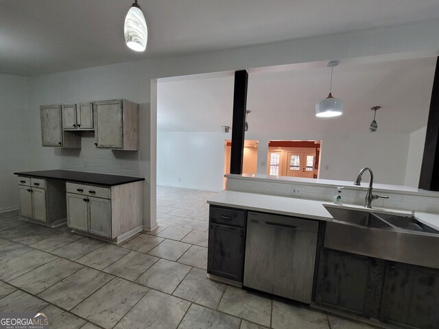 kitchen with light countertops, hanging light fixtures, vaulted ceiling, a sink, and dishwasher