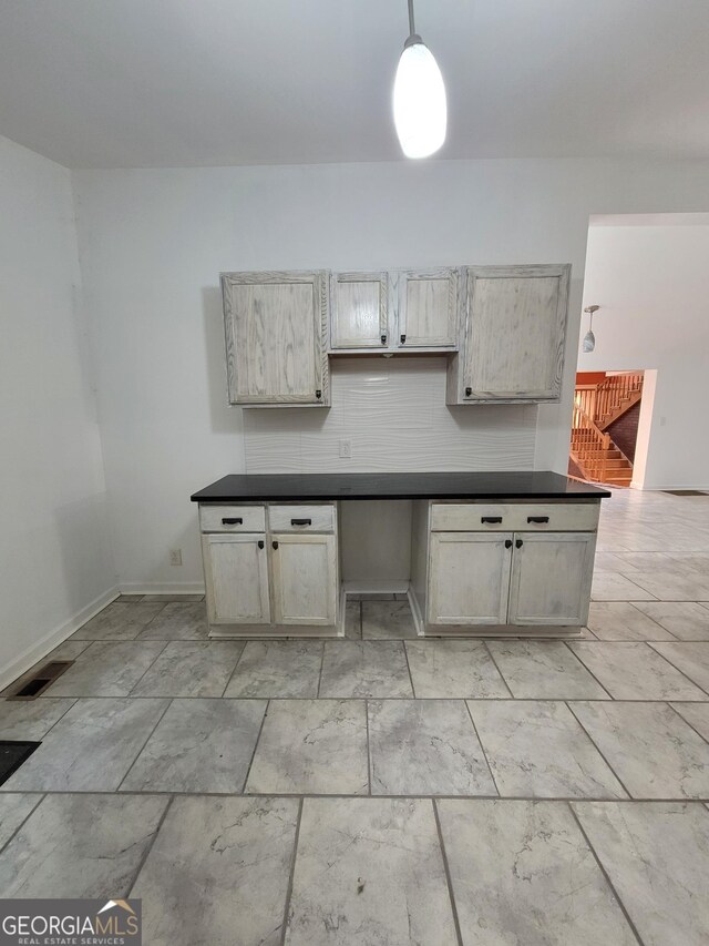 kitchen featuring decorative light fixtures, gray cabinets, backsplash, stainless steel dishwasher, and a sink