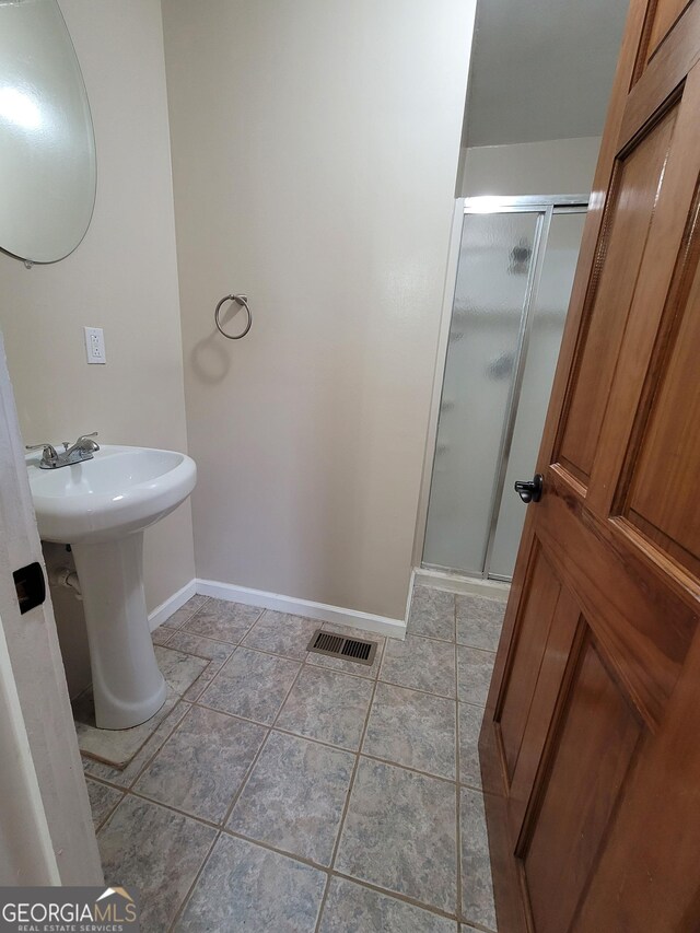 full bath with tiled shower and tile patterned floors