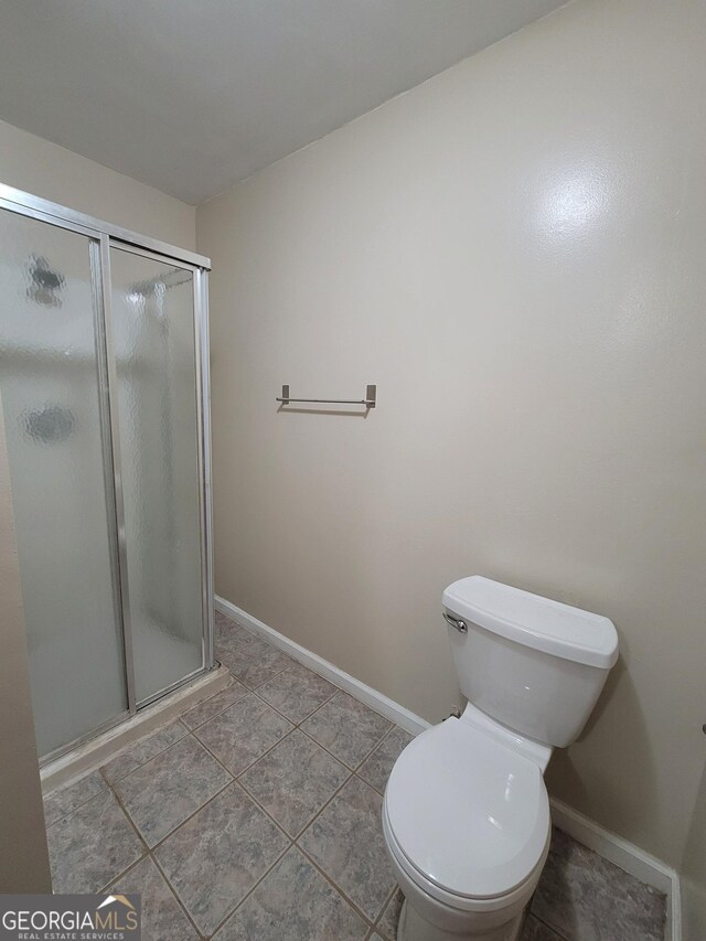 bathroom with a stall shower, baseboards, visible vents, and tile patterned flooring