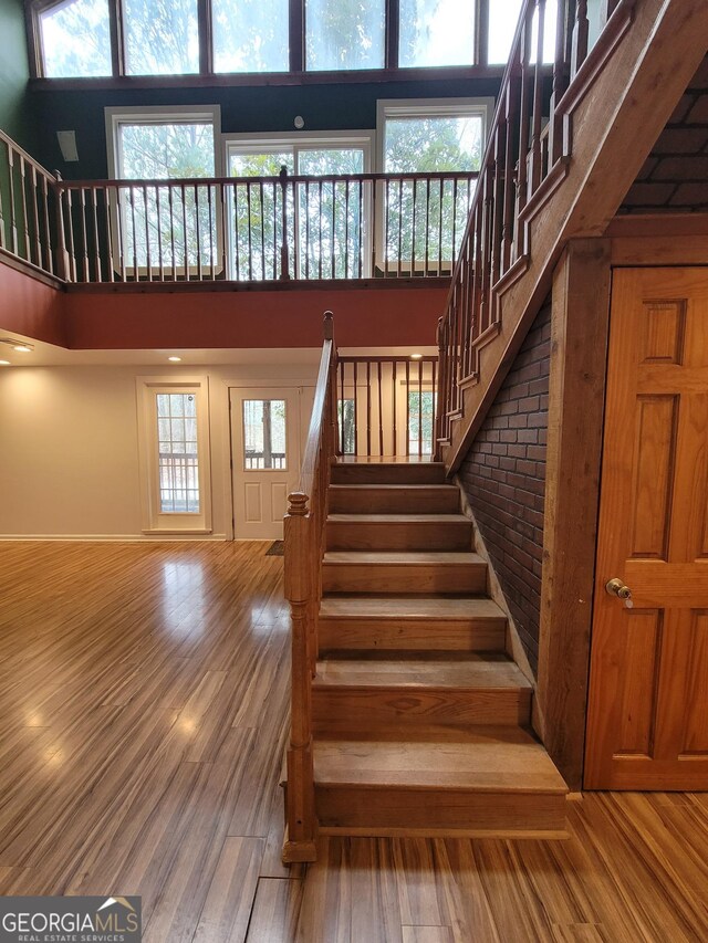 hall featuring light wood-style flooring, stairway, visible vents, and baseboards