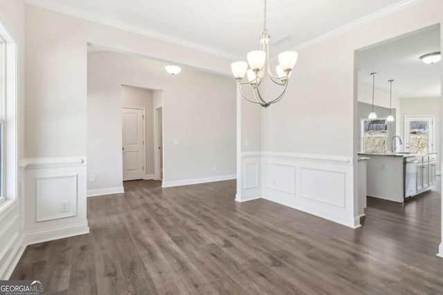 unfurnished dining area featuring a notable chandelier, ornamental molding, and dark wood-style flooring