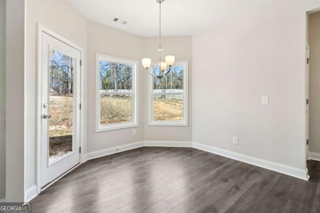 unfurnished dining area with dark wood-type flooring, visible vents, and plenty of natural light